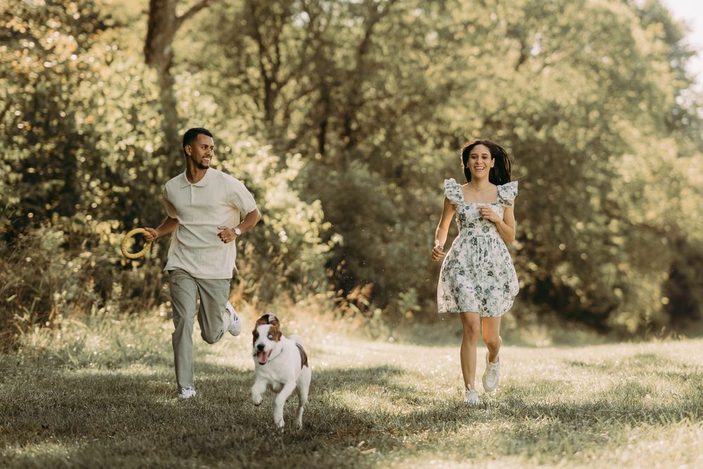 Outdoor engagement couple portrait in Manassas battlefield with puppy at golden hour
