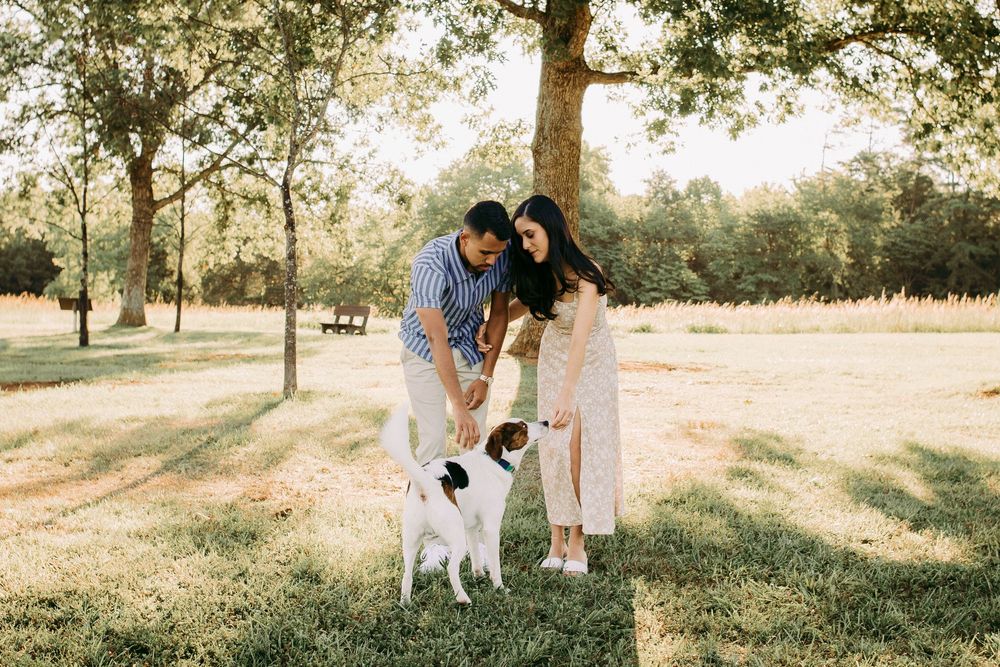 Outdoor engagement couple portrait in Manassas battlefield at golden hour with puppy